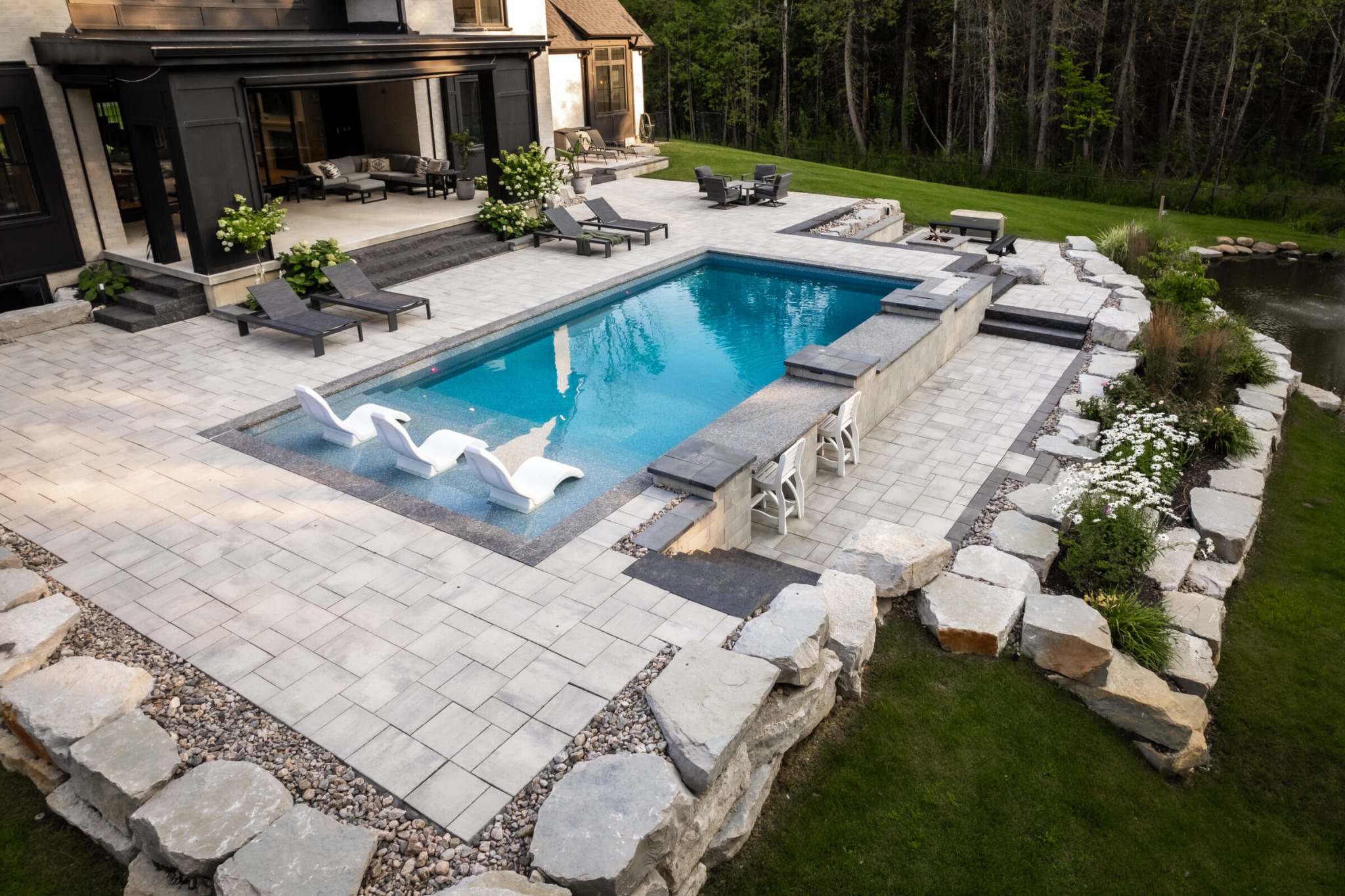 Natural stone outdoor living space with patio and landscaping